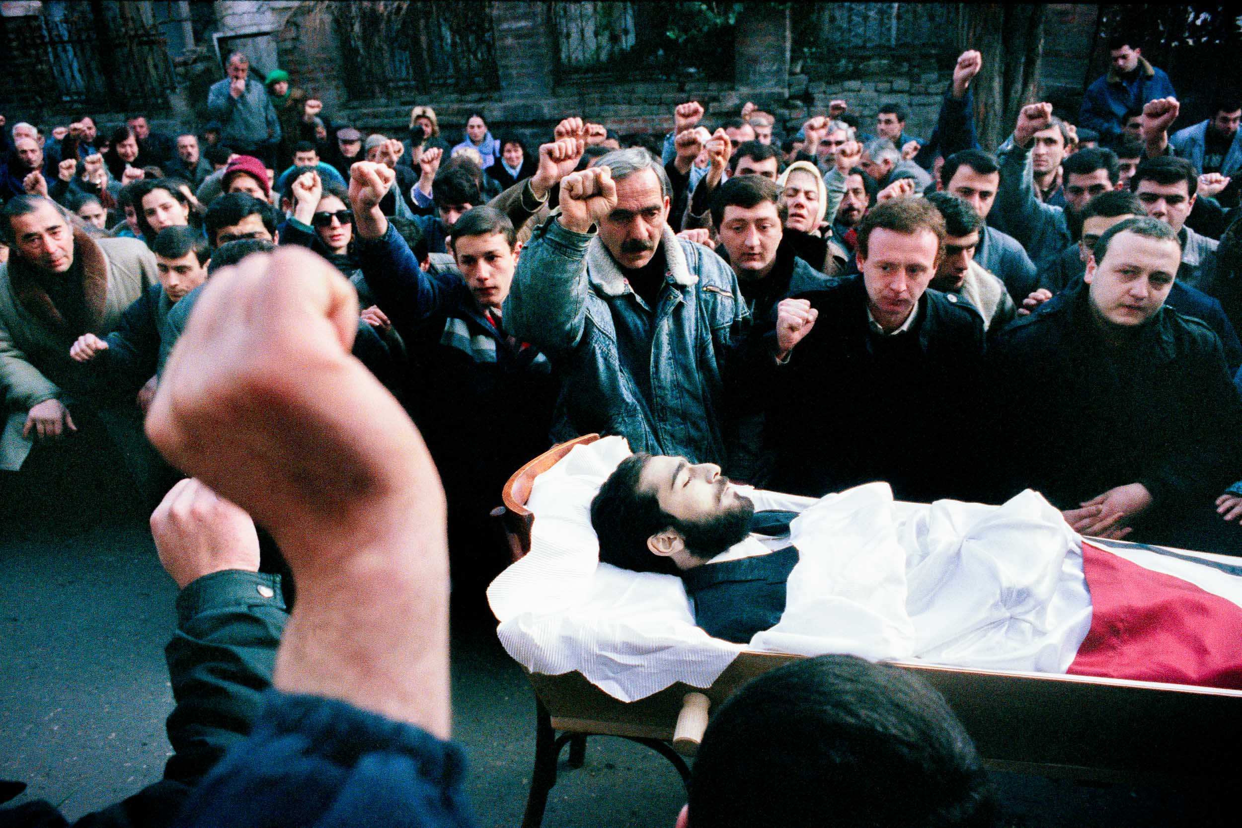 Mourners raises a fist over the body of  Levan Tactakichvili, at his funeral, Tbilisi, Georgia