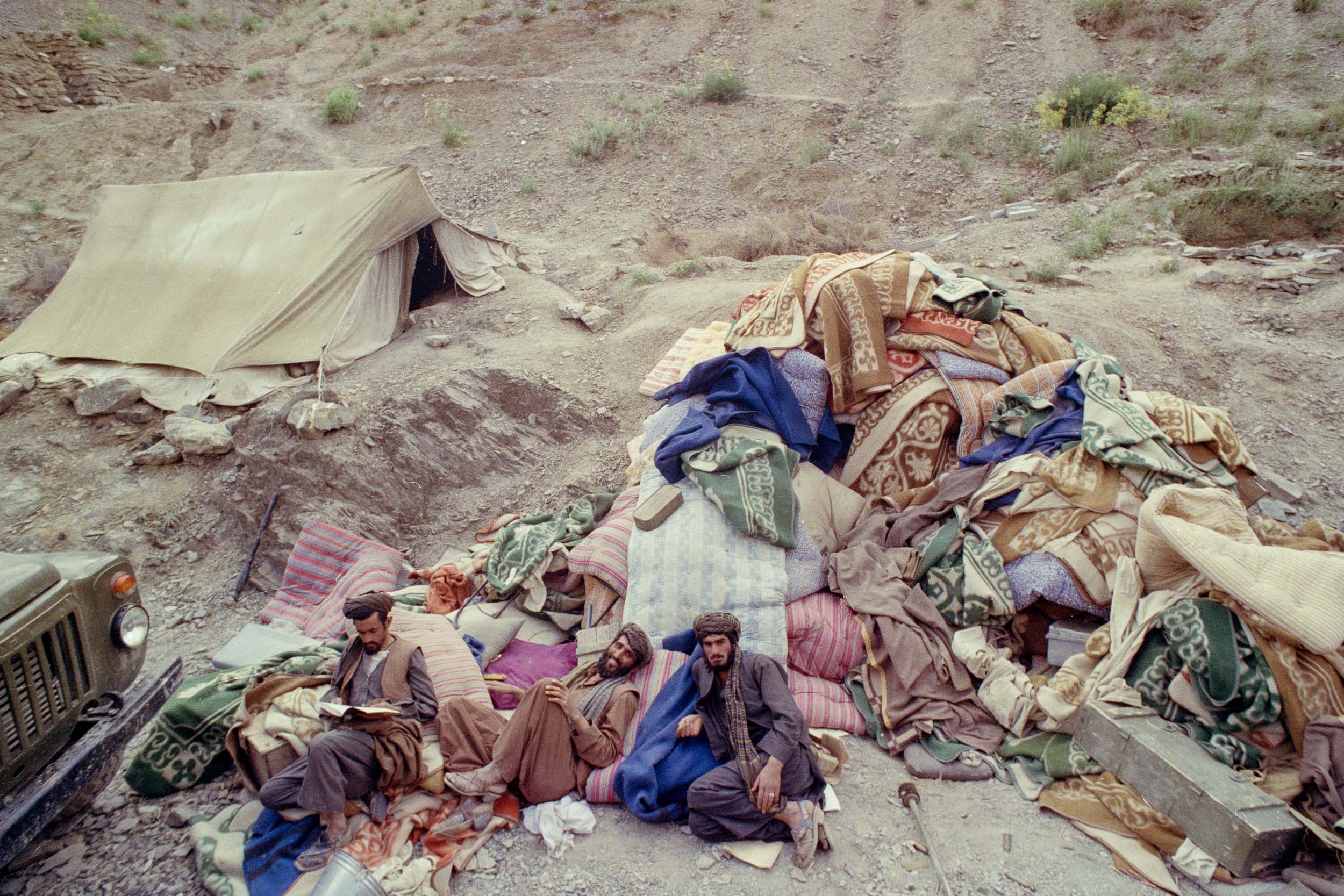 Mujahideen relax on surrendered mattresses in a gorge,  Afghanistan 1988