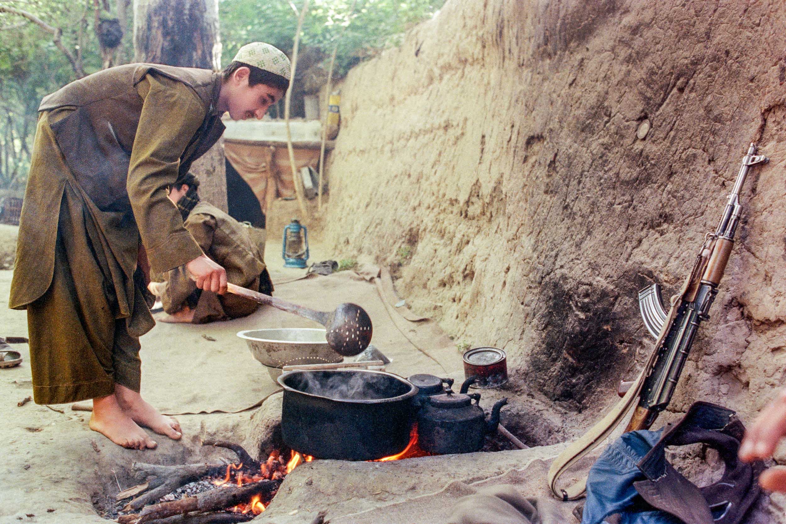 Mujahideen cooks lamb soup  in camp, Afghanistan 1988 