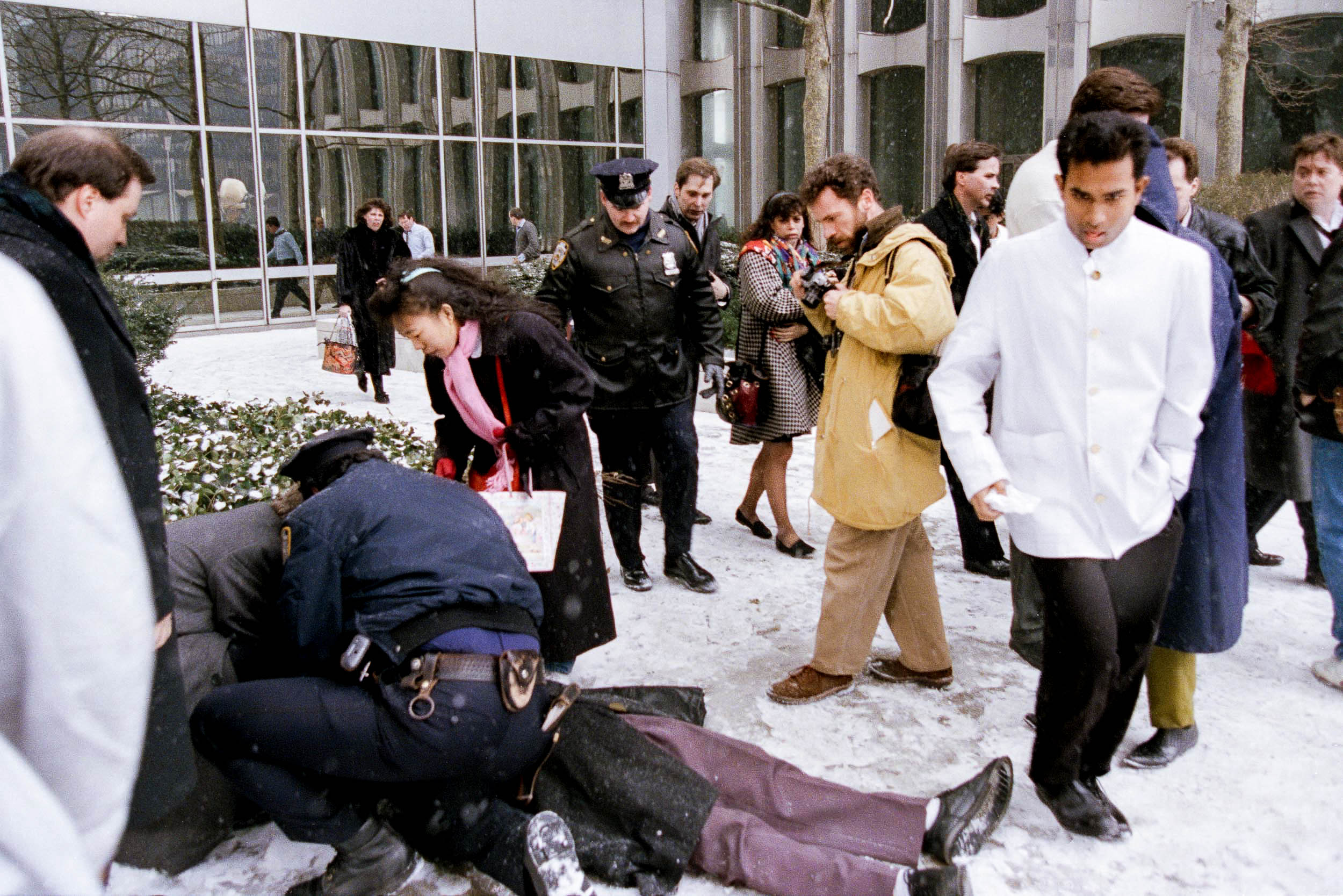 A policeman attends to a fallen office worker who slipped on the ice outside the World Trade Center, NY, 1993